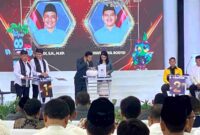 Terlihat Pasangan Riyadi - Wafi Abdul Rosyid saat mengenakan udeng dan selempang batik gedog khas Tuban pada debat perdana di salah satu resto di Tuban, (Ist).