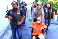 Suroto (baju orange) saat digelandang petugas Satreskrim Polres Ngawi dengan kursi roda untuk proses penyidikan. (Ist).