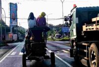 Selep Keliling melintas di jalan Ring Road Tuban, nampak para pekerja menaiki bagian atas selep tanpa yang tentu saja sangat membahayakan, (Assayid Annazili/Liputansatu.id).