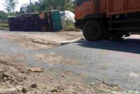 Sebuah truk terguling saat melintas di jalur ring road Tuban, diduga akibat kondisi jalan yang rusak, (Assayid Annazili/Liputansatu.id).