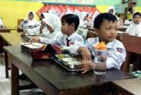 Siswa SDN 2 Mimbaan Kecamatan Panji, Situbondo menikmati menu makan bergizi gratis, (Fia Rahma/Liputansatu.id).