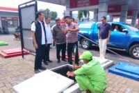 Pengawas SPBU Panji, Heriyanto saat menunjukkan hasil dipstick dari tandon ke Kasat Reskrim Polres Situbondo, AKP Agung Hartawan untuk memastikan BBM aman, (Fia/Liputansatu.id).