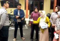 Warga Mlandingan Raudatul Husnah, menggelar aksi tunggal di halaman Mapolres Situbondo, terkait penanganan kasus pengeroyokan yang menimpanya, Kamis (28/12/2025), (Fia Rahma/Liputansatu.id).