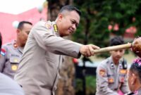 Plt Kapolres Tuban Kombespol Agung Setyo Nugroho menyiramkan air kelapa kepada personel yang naik pangkat sebagai simbol penyegaran dan tanggung jawab baru usai upacara kenaikan pangkat di Mapolres Tuban, Rabu (31/12/2025), (Assayid Annazili/Liputansatu.id).