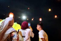 Pengunjung menerbangkan lampion saat perayaan Festival Cahaya Laut dalam rangka menyambut Tahun Baru 2026 di kawasan wisata Pantai Pasir Putih, Kecamatan Bungatan, Kabupaten Situbondo, (Fia Rahma/Liputansatu.id).