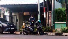 Seorang pelanggan kedai miras Wipy Friendship membawa botol miras, (Assayid Annazili/Liputansatu.id).