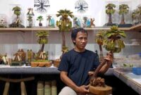 Putra Hadi Mulyo atau Mas Mul, pengrajin asal Desa Tegalagung, Semanding, Tuban, memperlihatkan karya seni miniatur pohon siwalan berbahan limbah alam yang telah dipasarkan hingga tingkat nasional dan mulai menembus pasar internasional, (Assayid Annazili/Liputansatu.id).