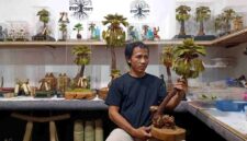 Putra Hadi Mulyo atau Mas Mul, pengrajin asal Desa Tegalagung, Semanding, Tuban, memperlihatkan karya seni miniatur pohon siwalan berbahan limbah alam yang telah dipasarkan hingga tingkat nasional dan mulai menembus pasar internasional, (Assayid Annazili/Liputansatu.id).