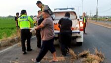 Petugas kepolisian mengevakuasi jenazah korban kecelakaan lalu lintas di jalur Pantura Tuban, (Assayid Annazili/Liputansatu.id).