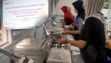 Petugas SPPG Desa Tahulu mencuci perlengkapan makan menggunakan pasokan air bersih dari program pipanisasi CSR SIG Pabrik Tuban di Dusun Bancang, Kecamatan Merakurak, (Assayid Annazili/Liputansatu.id).