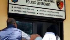 Tersangka kasus pembunuhan bidan RSUD Besuki didampingi petugas saat berada di depan ruang Satreskrim Polres Situbondo untuk menjalani pemeriksaan dalam proses penyidikan, (Fia Rahma/Liputansatu.id).