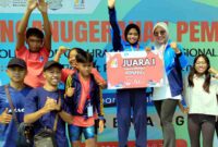 Salwa Kaysa Adnafika (tengah) berfoto bersama pelatih, keluarga, dan tim usai meraih Juara I Olimpiade Olahraga Siswa Nasional (O2SN) cabang renang putri tingkat Provinsi Jawa Timur di GOR Delta Sidoarjo. Prestasi tersebut mengantarkan siswi UPT SDN Tasikmadu 1 Tuban itu menjadi wakil Jawa Timur pada O2SN tingkat nasional, (Assayid Annazili/Liputansatu.id).