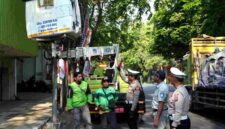 Petugas Satlantas Polresta Tuban bersama DLHP, Jasa Raharja, dan komunitas ojol memasang lampu blue light di salah satu titik rawan kecelakaan atau blackspot di Kabupaten Tuban, (Assayid Annazili/Liputansatu.id).